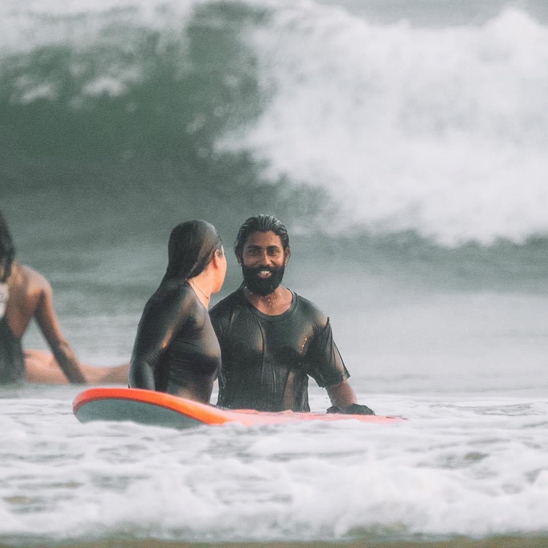 Lahiru coaching a surfer in the water at Weligama
