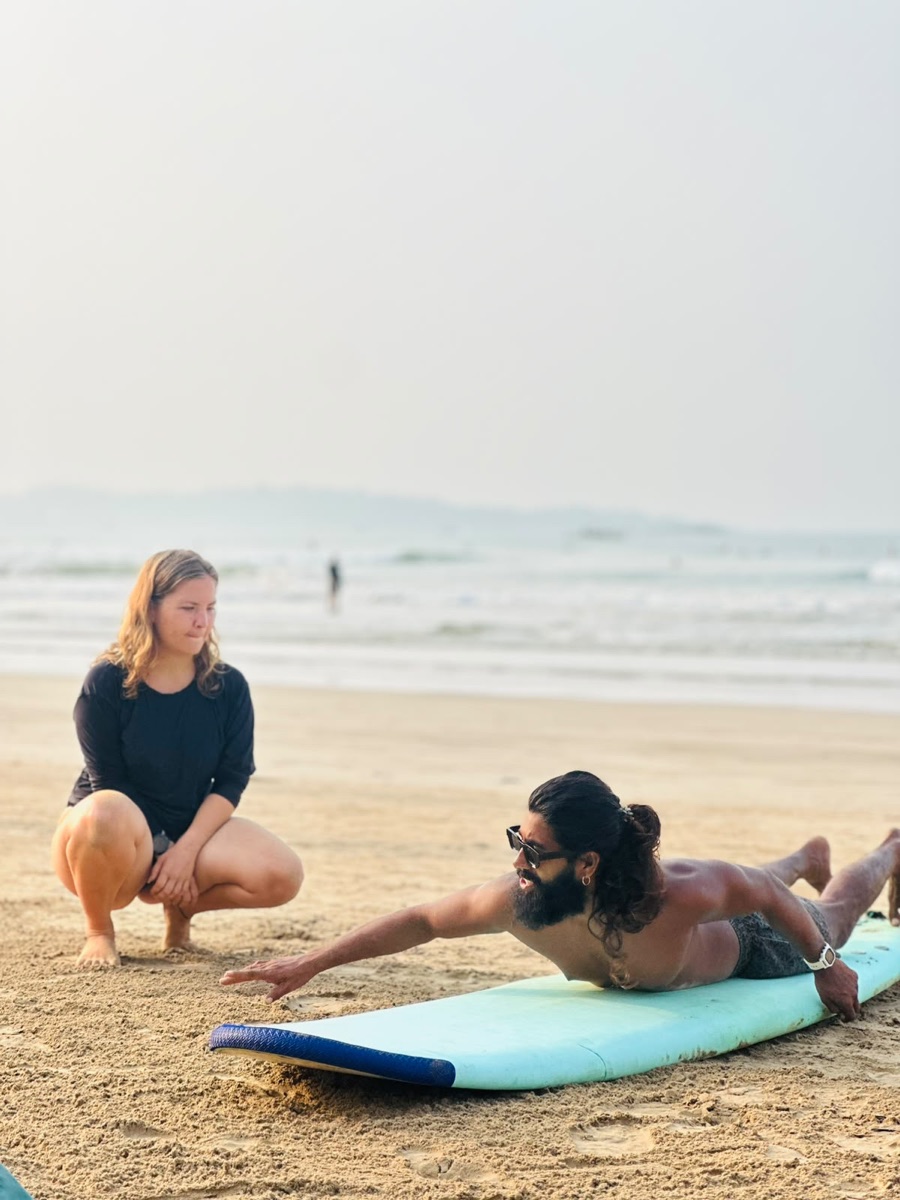 Lahiru demonstrating a paddling technique to a beginner on Weligama beach